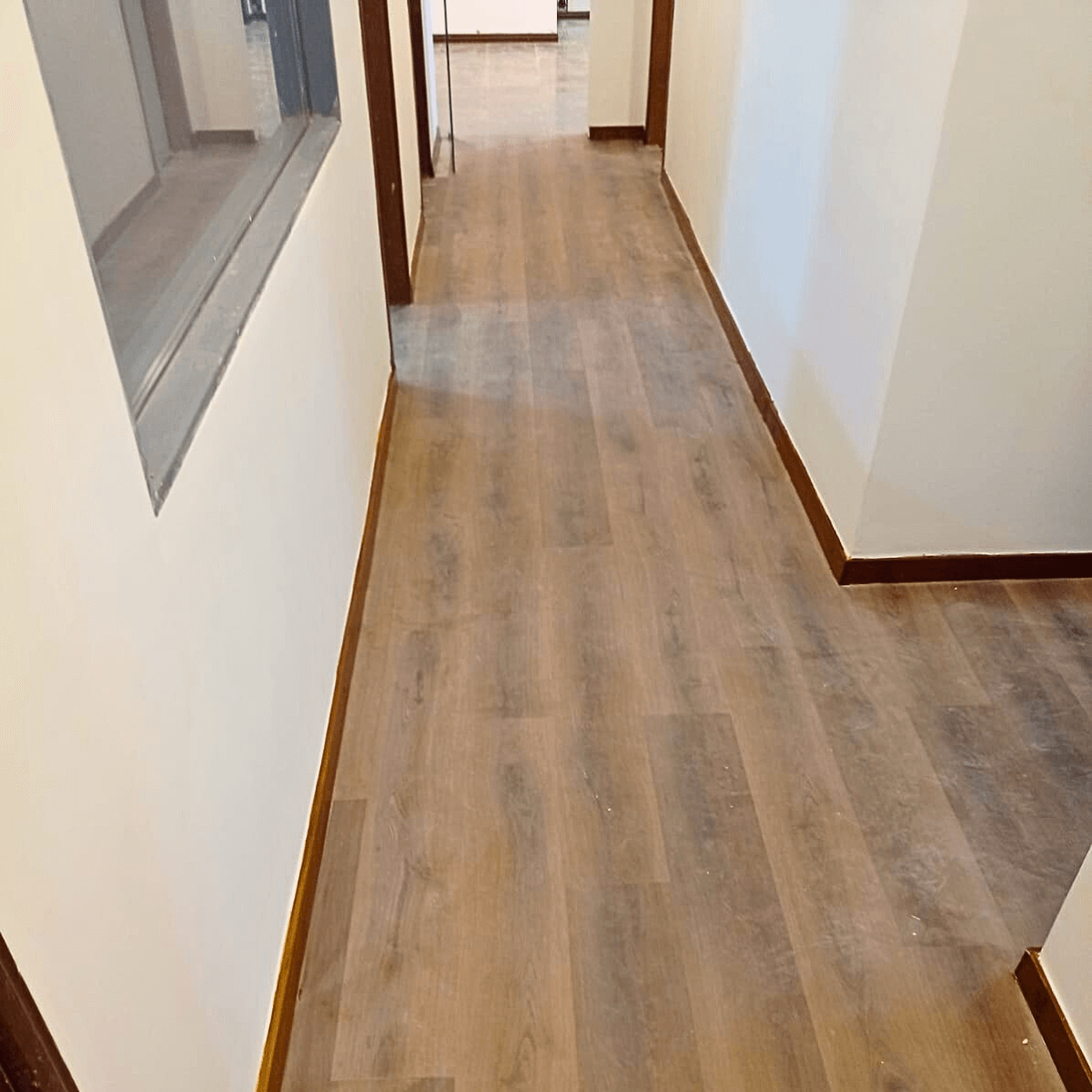 Instalação de piso em corredor com alinhamento perfeito das réguas e acabamento nos batentes.