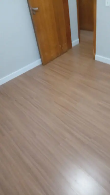 Sala residencial recém-reformada com instalação de piso vinílico claro sem quebra-quebra, obra limpa realizada em Palmas, TO.